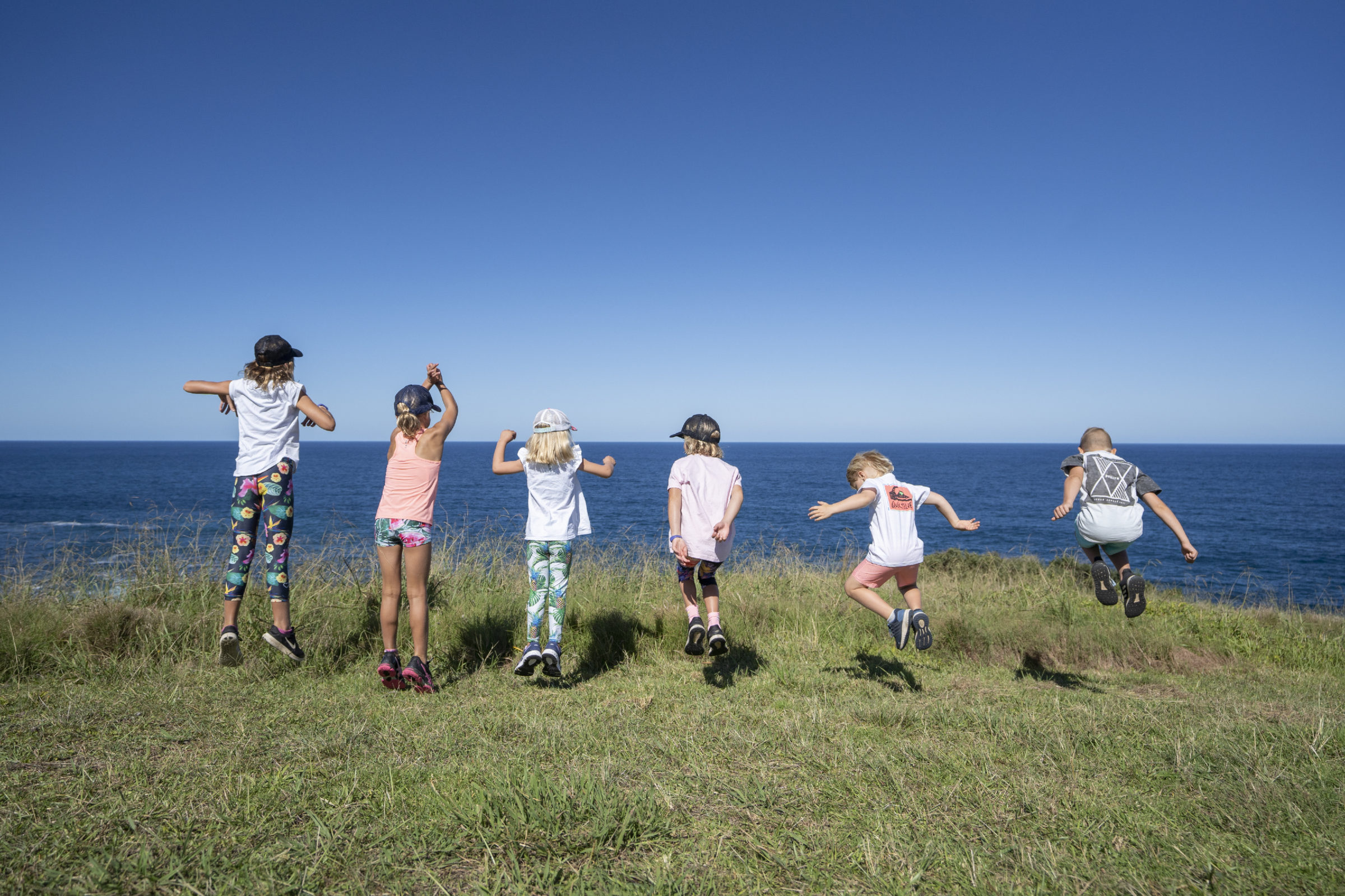 Peter Izzard Photography - Kids Jumping on Coast Walk
