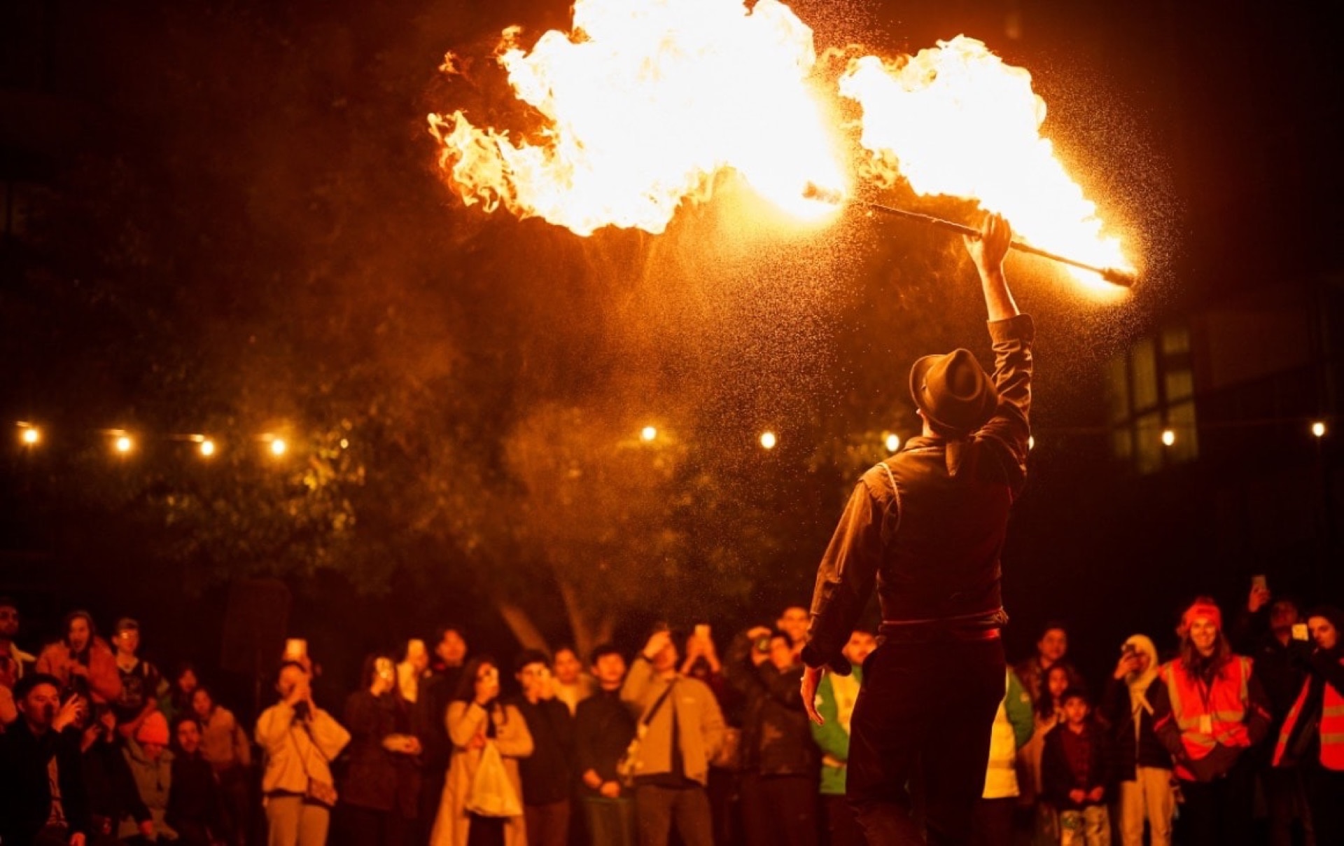 man twirling fire in front of a crowd